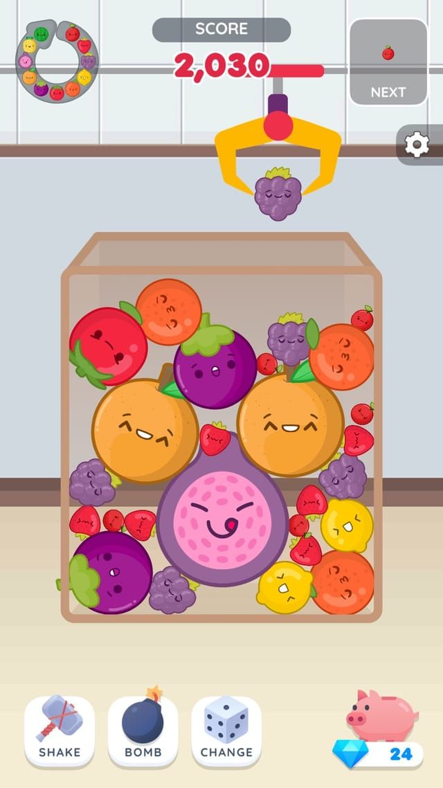 The fruit theme in play: a jar filling up with merged fruit faces, the claw at the top holding the next grape to drop.